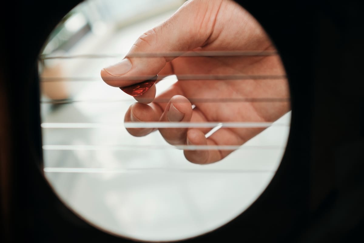 A person holding a guitar pick
